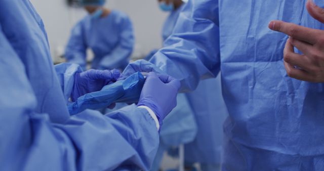 Midsection of surgeons in operating theatre wearing latex gloves preparing to surgery. medicine, health and healthcare services.
