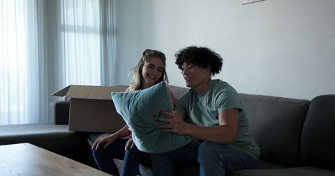 Young couple unpacking boxes organizing new living room