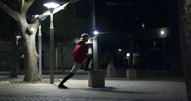 Young Man Stretching Outdoors at Night Under Streetlights - Download Free Stock Images Pikwizard.com