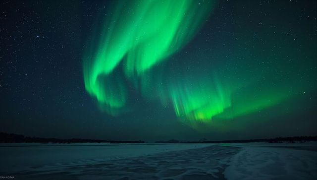 Mesmerizing Aurora Borealis Over Icy Landscape With Stars