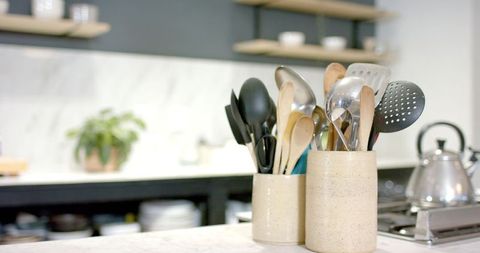 Elegant kitchen with utensil holders and marble backsplash