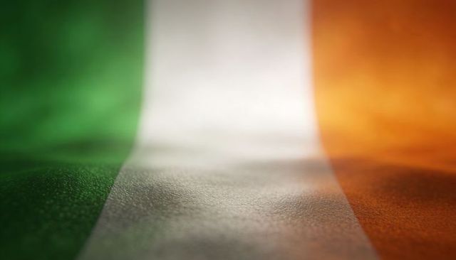 Closeup irish flag fabric tricolor showing woven texture folds and light reflection