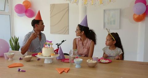 Family Together Celebrating Child's Birthday with Cake and Snacks
