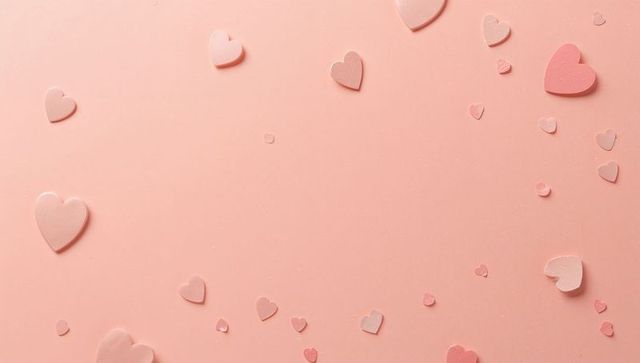 Scattering pastel heart cutouts with confetti on soft pink backdrop for romantic minimal flatlay des
