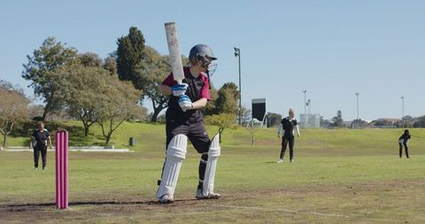 Female Cricket Player in Action During Lively Outdoor Match