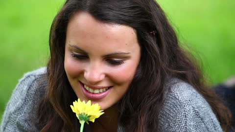 Smiling Brunette Enjoying Nature's Fragrance in Park