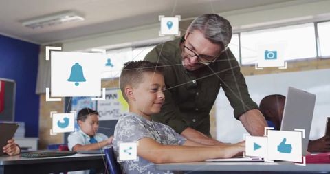 Teacher assisting boy with digital learning tools