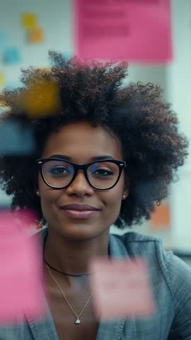 Vertical video professional closing eyes adjusting pink sticky note during brainstorming