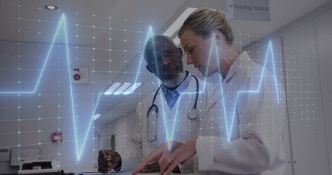 Doctors discussing medical report amid electrocardiogram display