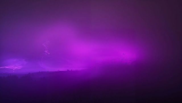 Enchanting Purple Mist Over Forest Horizon at Night