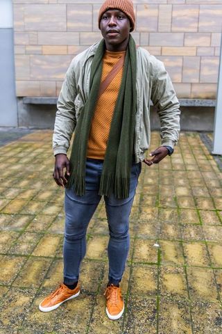 Stylish african american man standing in urban courtyard wearing autumn streetwear
