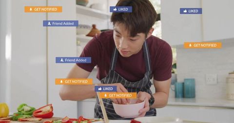 Teen boy cooking with social media notifications at home