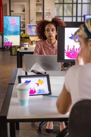 Creative team collaborating on digital marine life illustrations in modern studio