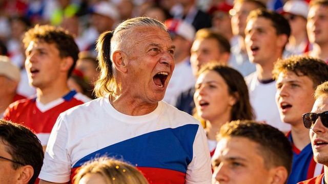 Energetic senior male fan shouting and cheering in crowded stadium during live football match