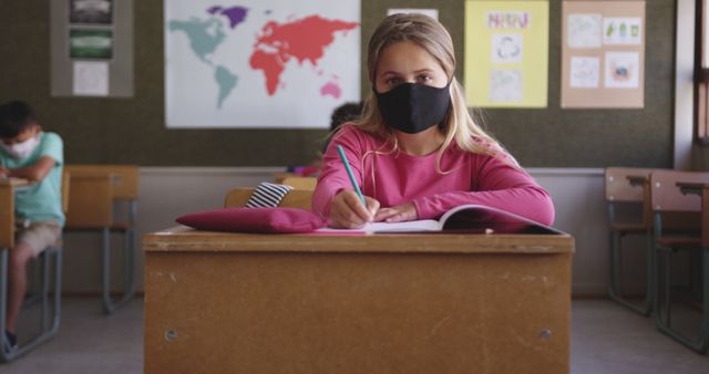 Young Student Wearing Face Mask While Writing in Classroom - Download Free Stock Images Pikwizard.com