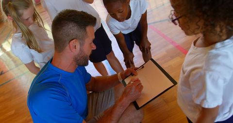 Teacher Guiding Students in Basketball Strategy Session