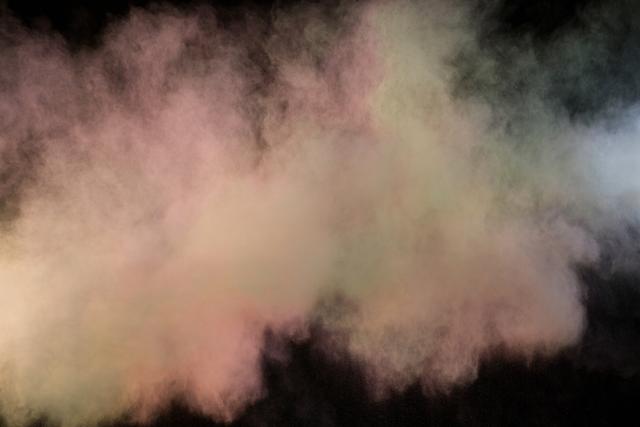 Vibrant cloud of colored powder suspended against a black background shows dynamic forms and textures. Perfect for festival celebrations, artistic projects, creative designs, advertisements, and energetic visuals.