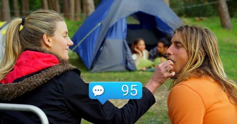 Adventurous Friends Sharing Snacks at Cozy Campsite