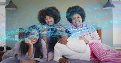 Cozy pajama party family bonding on bed laughing together during relaxed morning