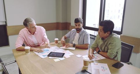 Diverse business meeting with charts and tablet technology