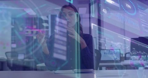 Female analyst gesturing at augmented reality data dashboards in modern office