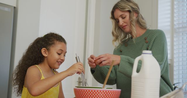 Image of biracial daughter and caucasian mother cooking together. Family life, spending time together with family.