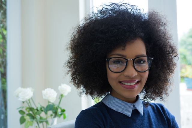 Smiling Woman with Curly Hair and Glasses in Bright Room - Download Free Stock Photos Pikwizard.com