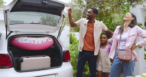 Happy Family Packing Car with Summer Vacation Items for Trip
