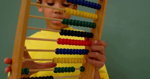 Focused Young Boy Using Colorful Abacus for Learning
