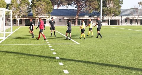 Soccer Players Strategizing on Field During Training Session