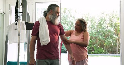 Senior Couple Enjoys Home Fitness Routine with Relaxing Smiles