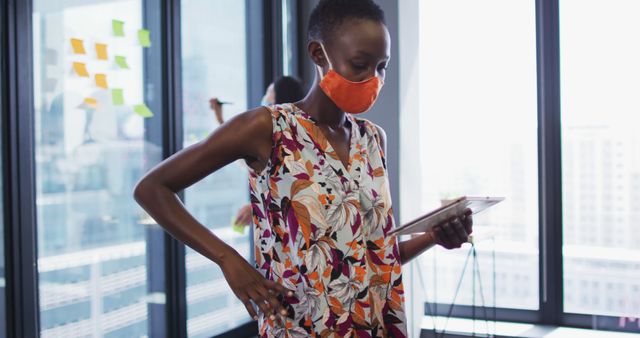 Businesswoman Using Tablet in Office Wearing Face Mask - Download Free Stock Images Pikwizard.com