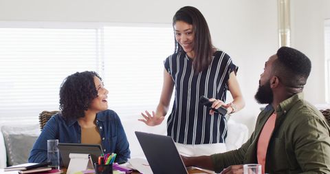 Cheerful multicultural team collaborating at home workspace