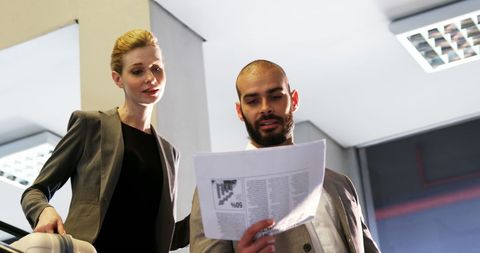 Business Professionals Analyzing Document in Airport Lounge