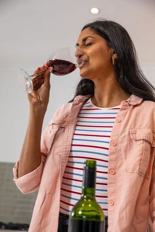 Woman Enjoying Red Wine in Modern Kitchen Setting