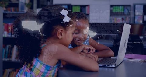 Girls collaborating on laptop in library with digital world map overlay for global learning