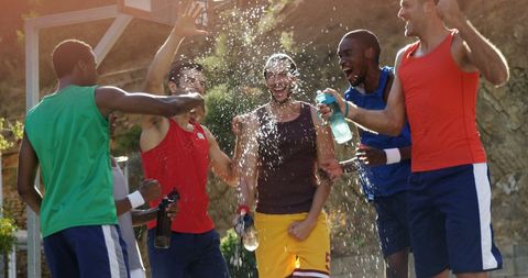 Outdoor Basketball Team Celebration with Water Splashes