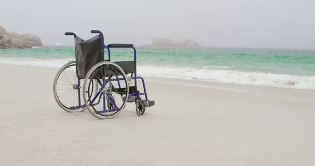 Empty wheelchair at beach on a sunny day. Sea waves in the background 4k