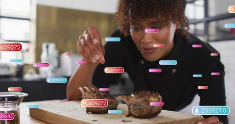 Chef seasoning lamb chops with digital interaction in gourmet kitchen
