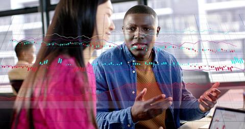 Professionals analyzing candlestick charts with laptop, discussing financial data trends