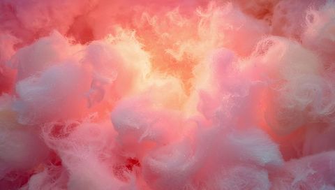 Glowing pastel cotton-candy fibrous tufts illuminating backlit spun-sugar macro texture