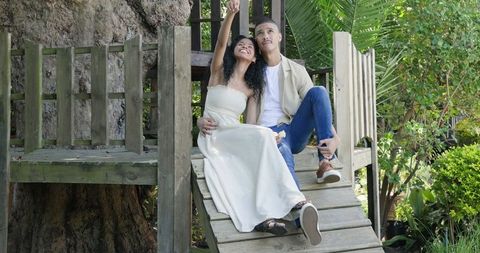 Happy Couple Relaxing on Outdoor Slide While Enjoying Nature