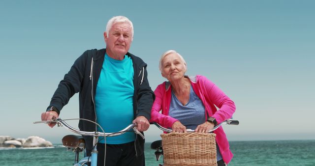 Older couple riding bicycles and enjoying a sunny day by the ocean, promoting an active and healthy lifestyle for seniors. Great for campaigns on healthy living, retirement, adventure travel, and leisure activities. Can also be used in advertisements targeting older adults looking to stay fit and active.