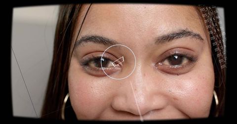 Biometric close-up headshot of smiling woman with futuristic reticle and data readouts