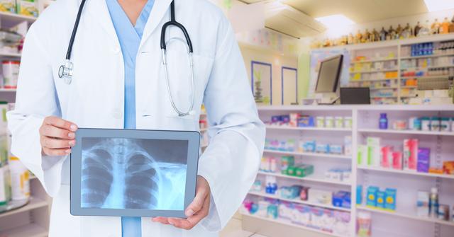 Doctor holding tablet displaying chest x-ray in a pharmacy. Ideal for illustrating modern healthcare, digital health technology, medical diagnostics, and professional medical services.