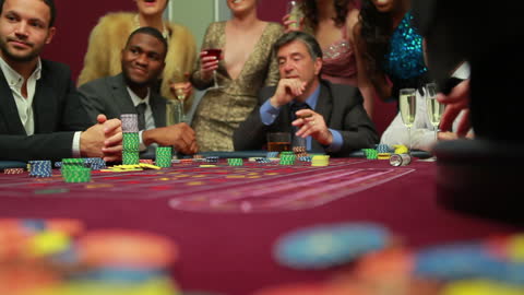 Men Gathering Around Casino Table Awaiting Dealer's Move