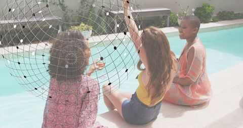 Three women chatting by pool with wireframe globe overlay, summer backyard lifestyle