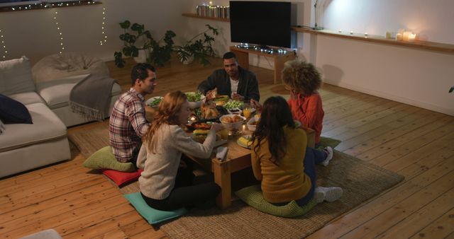 Friends Gathering Around Low Table for Festive Meal in Cozy Living Room - Download Free Stock Images Pikwizard.com