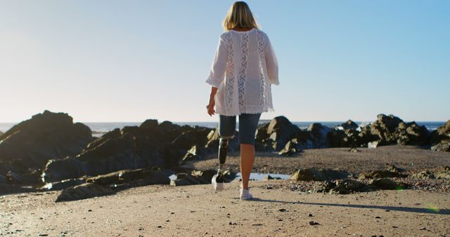 Woman with Prosthetic Leg Walking on Rocky Beach - Download Free Stock Images Pikwizard.com