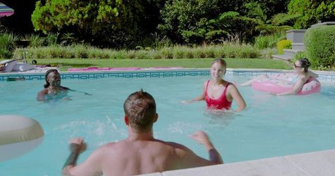Diverse friends enjoying summer fun in backyard pool